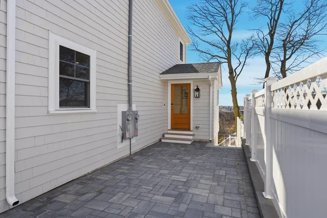 a view of a house with a large window and wooden fence