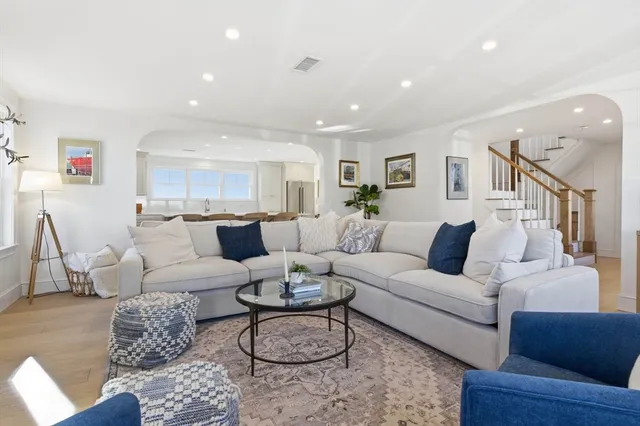 a living room with furniture and a dining table with kitchen view