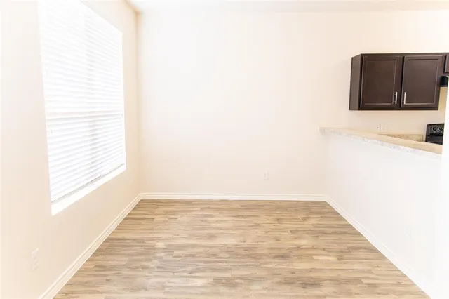 a view of a room with wooden floor and a window