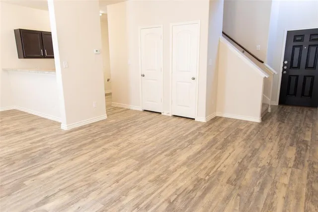 an empty room with wooden floor and entryway