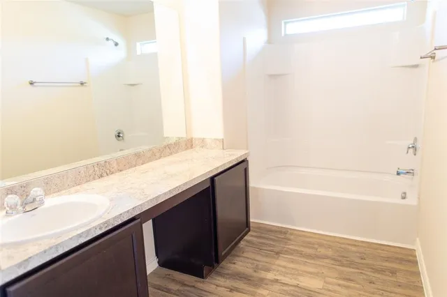 a bathroom with a granite countertop sink a toilet and shower