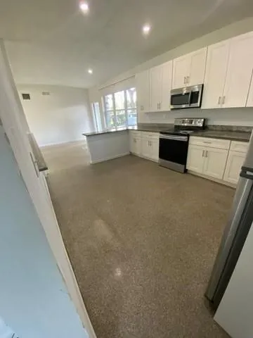 a kitchen with stainless steel appliances granite countertop a stove a sink and a refrigerator