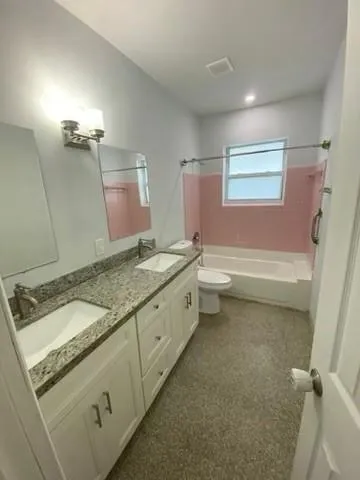 a bathroom with a granite countertop sink a toilet and a bathtub