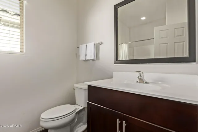 a bathroom with a sink a toilet a mirror and vanity