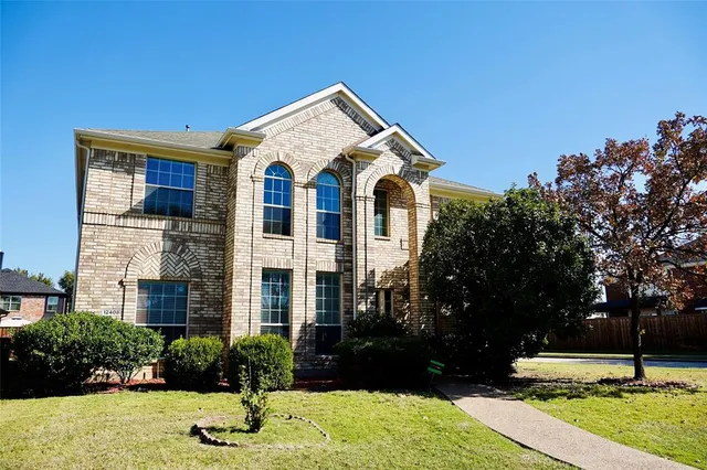 a view of a big house with yard and plants