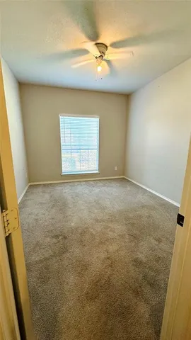 en empty room with windows and fan