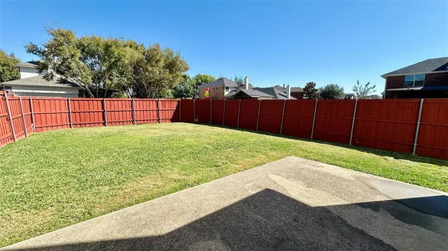 a view of a backyard with wooden fence