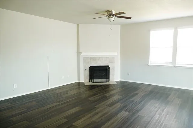 a view of empty room with wooden floor and fireplace