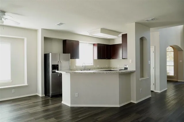 a kitchen with stainless steel appliances granite countertop a refrigerator a sink and a stove