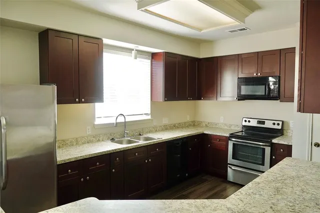 a kitchen with a sink appliances and cabinets
