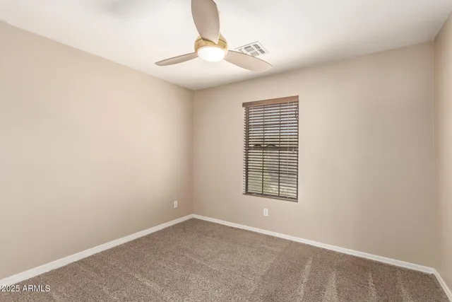 an empty room with closet and a chandelier fan
