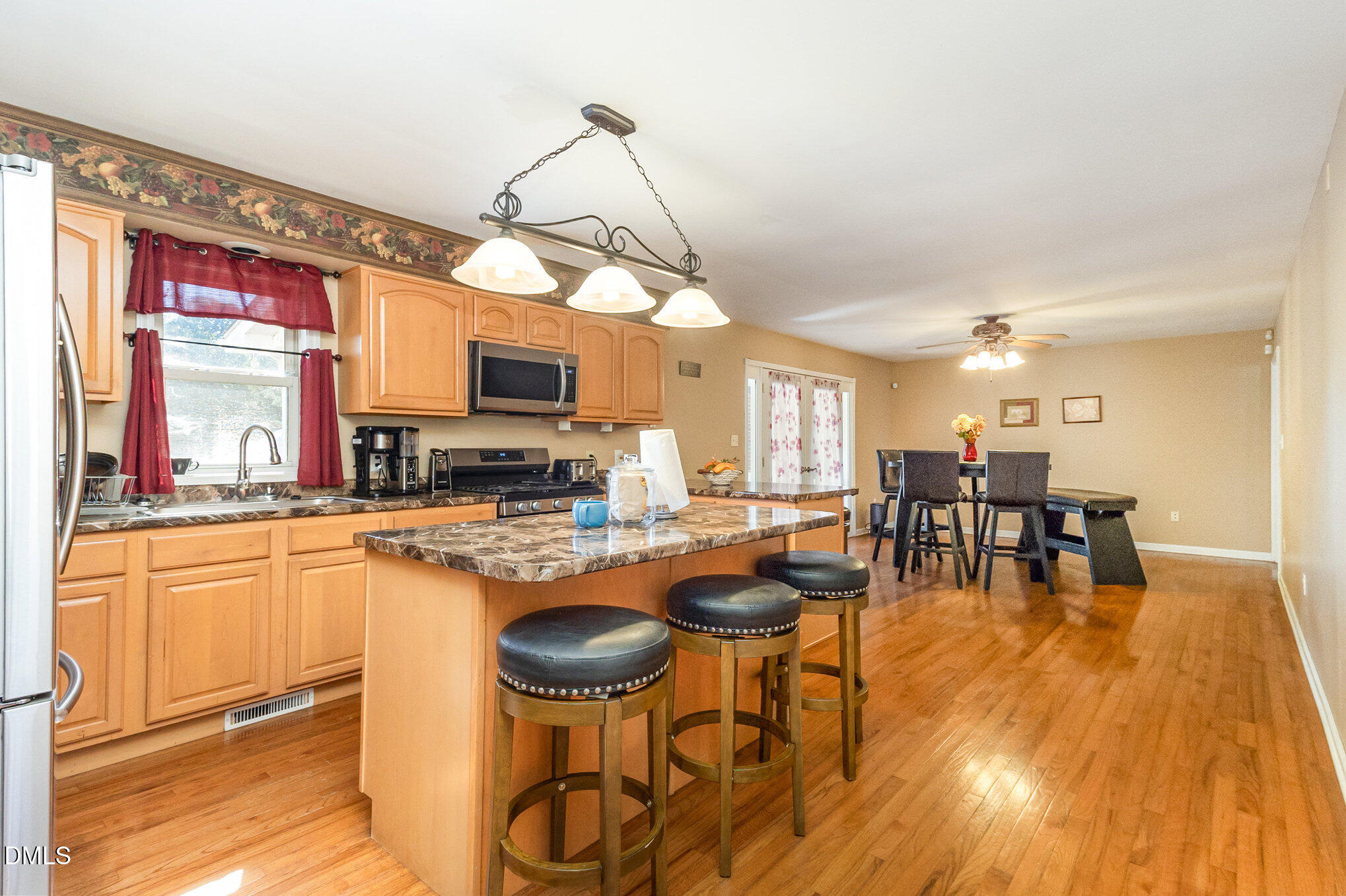 376-t K T K Allen Road Louisburg, NC 27549 - Photo 13 of 39 a kitchen with stainless steel appliances granite countertop a stove a refrigerator a kitchen island a dining table and chairs with wooden floor