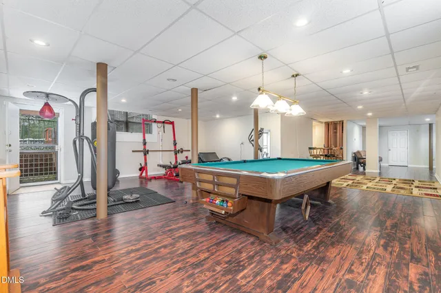 a room with wooden floors and pool table