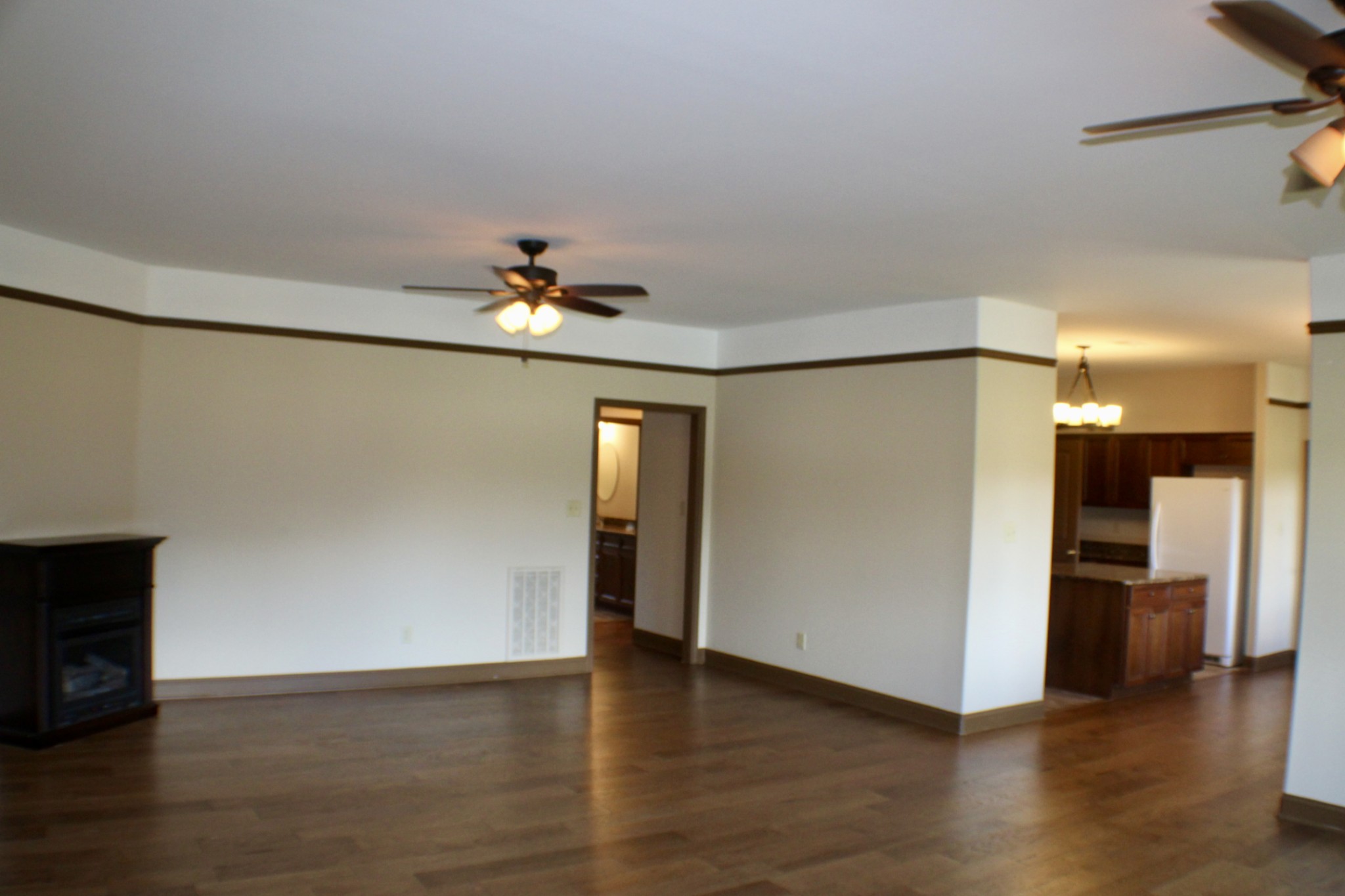 935 Lakeview Drive Collierville, TN 38017 - Photo 51 of 82 a view of an empty room with wooden floor and a kitchen