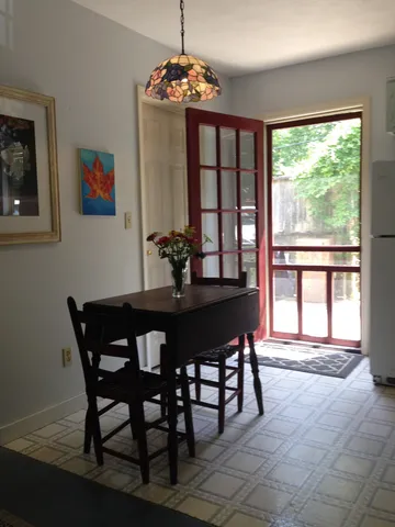 a dining room with furniture a rug and a large window