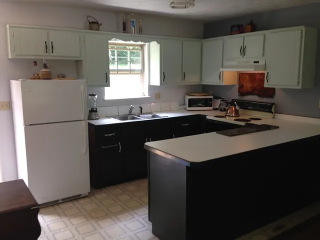 a kitchen with a sink a stove a refrigerator and cabinets