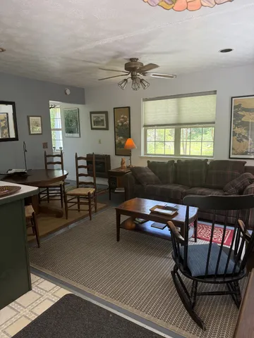 a living room with furniture a rug and a window