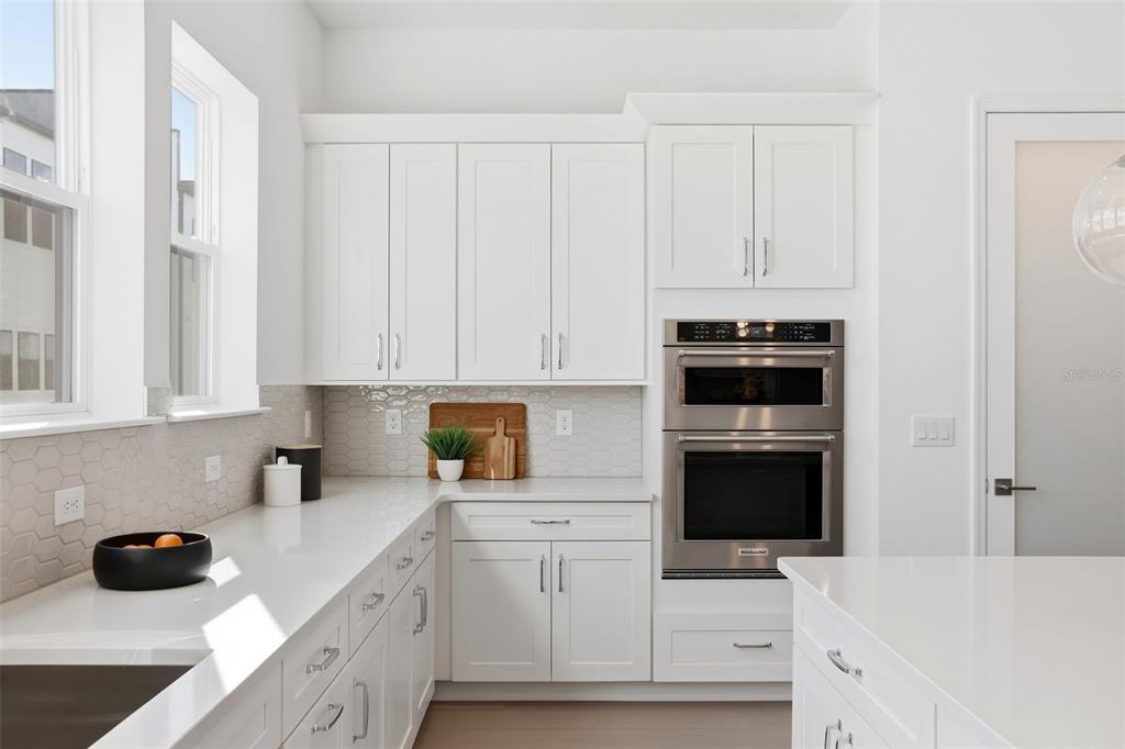 2174 Whitney Marsh Alley Orlando, FL 32804 - Photo 11 of 50 a kitchen with white cabinets and black appliances