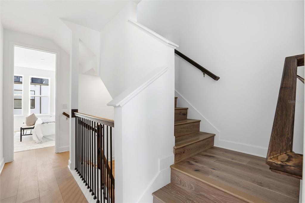 2174 Whitney Marsh Alley Orlando, FL 32804 - Photo 16 of 50 a view of a hallway with wooden floor and staircase