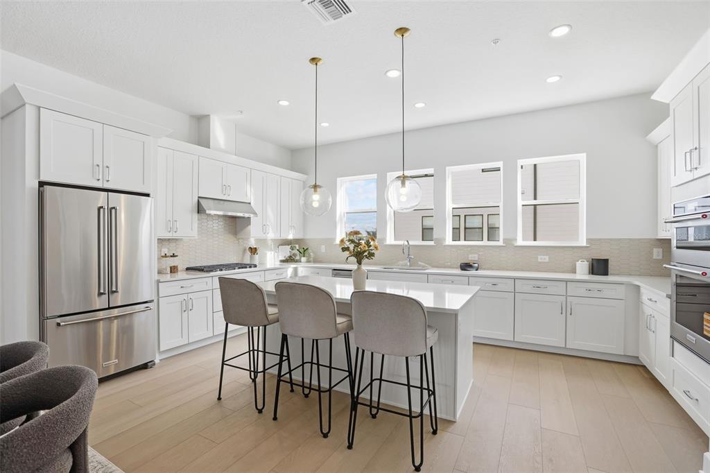 2174 Whitney Marsh Alley Orlando, FL 32804 - Photo 7 of 50 a kitchen with stainless steel appliances granite countertop a table chairs sink refrigerator and cabinets