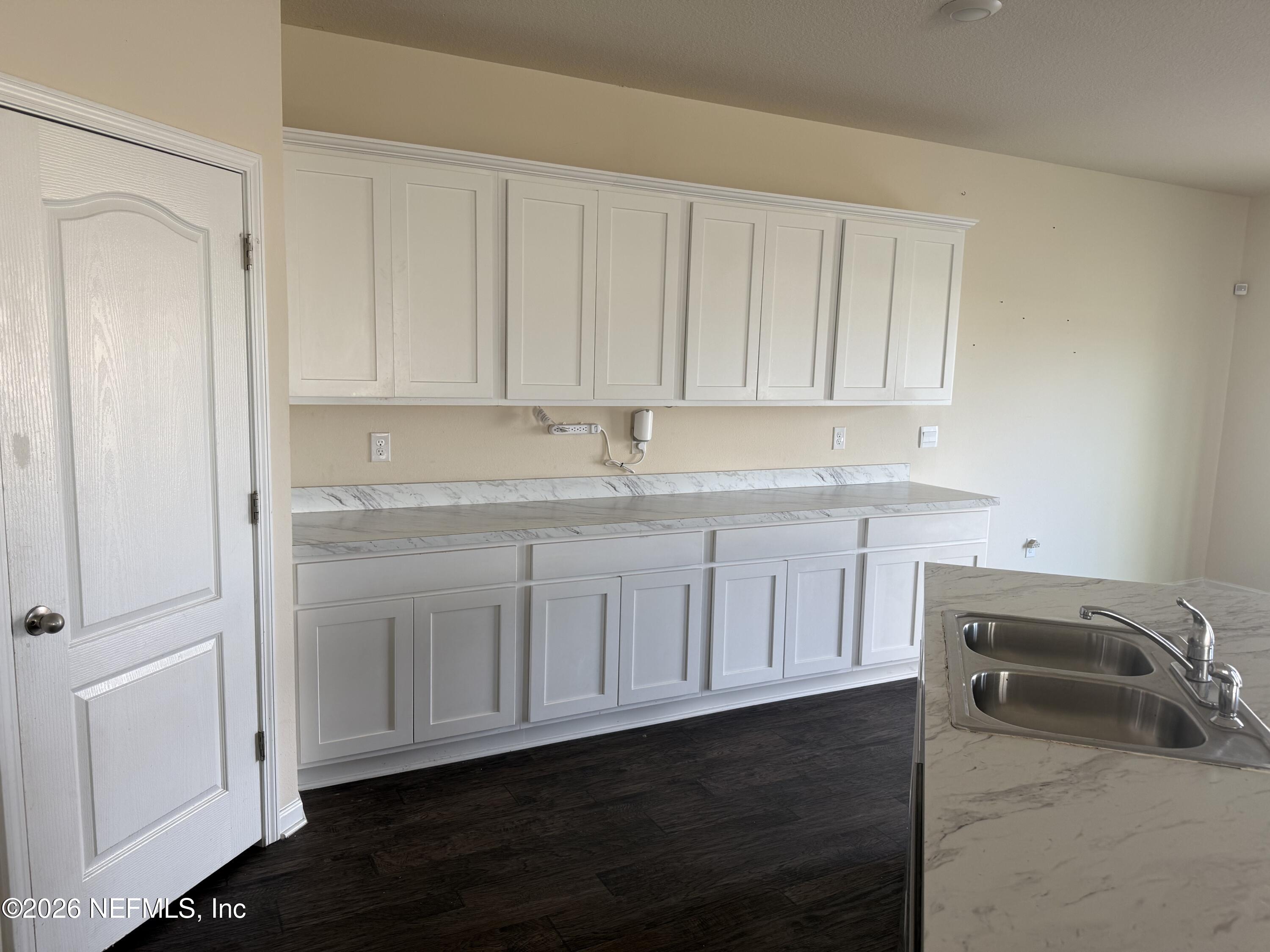 150 Aveiro Way Street St. Augustine, FL 32084 - Photo 3 of 68 a kitchen with granite countertop white cabinets and sink
