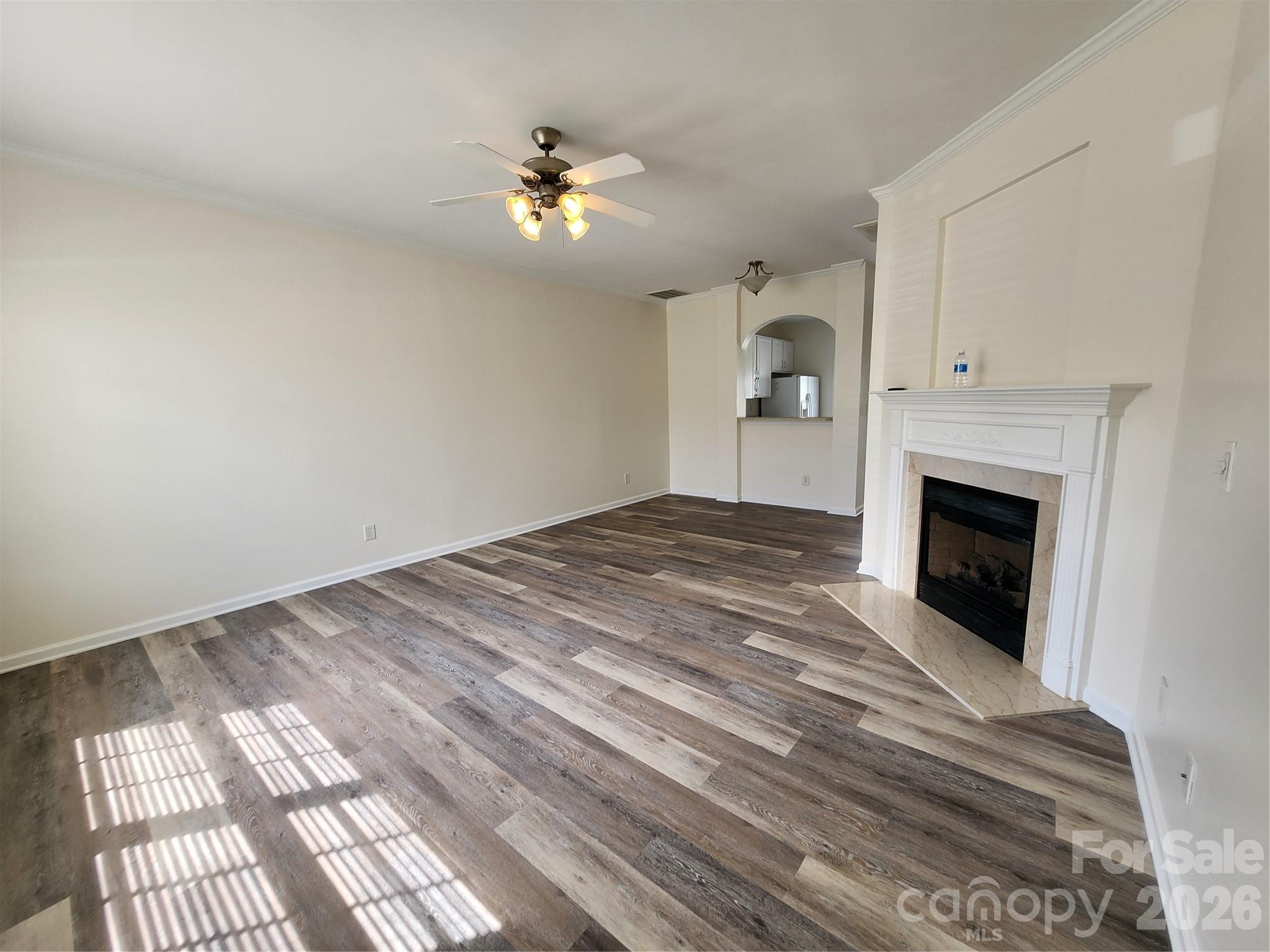 824 Gentlewinds Court Fort Mill, SC 29708 - Photo 6 of 30 a view of an empty room with a fireplace and chandelier fan