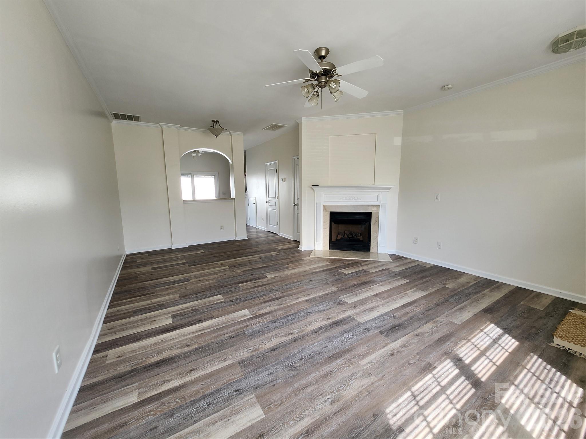 824 Gentlewinds Court Fort Mill, SC 29708 - Photo 7 of 30 a view of an empty room with a fireplace and chandelier fan