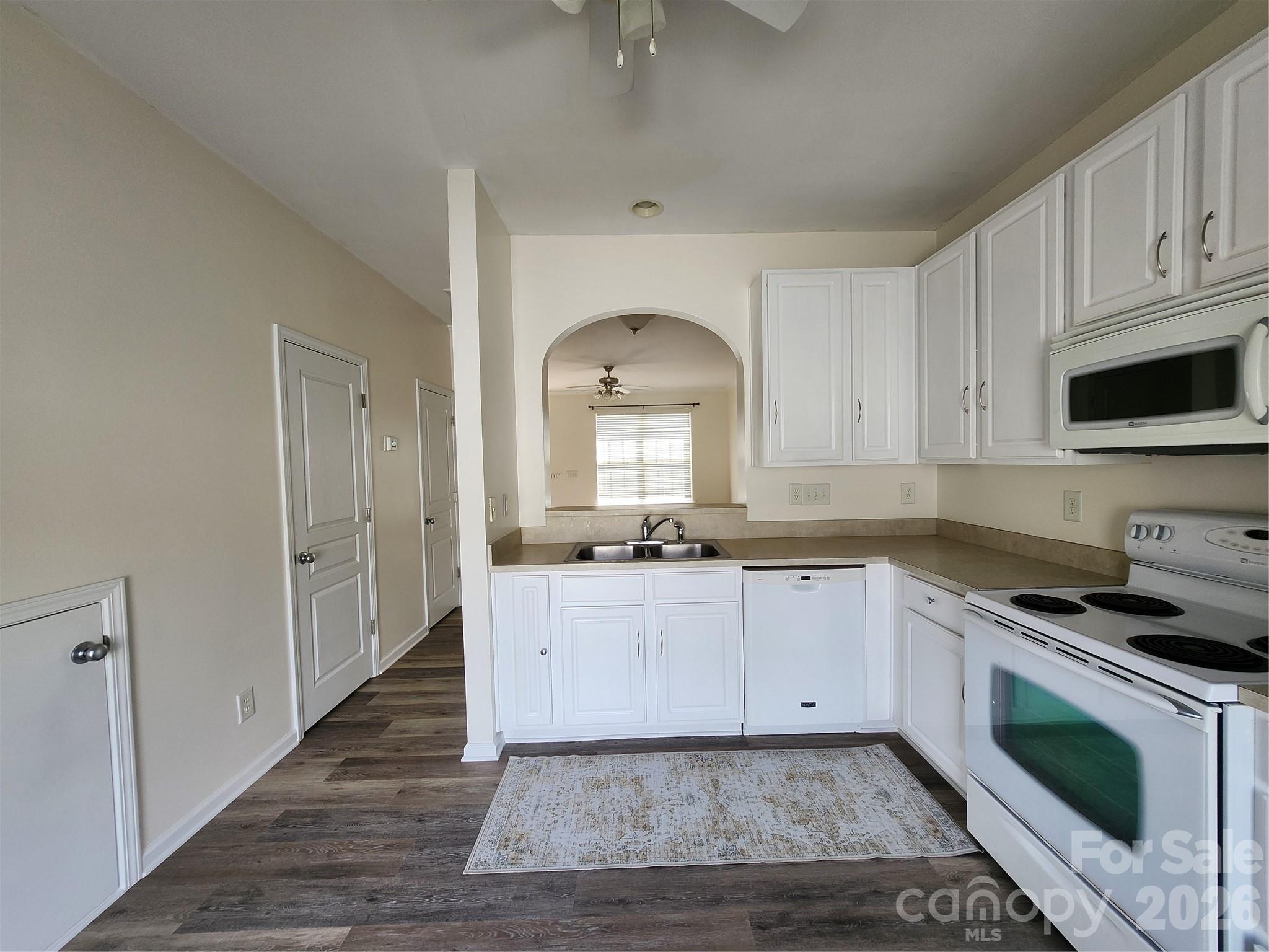 824 Gentlewinds Court Fort Mill, SC 29708 - Photo 8 of 30 a kitchen with granite countertop a sink and a stove top oven with white cabinets