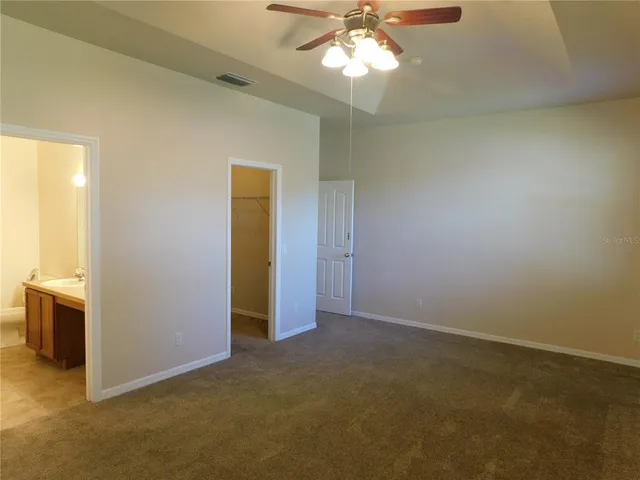 an empty room with chandelier fan