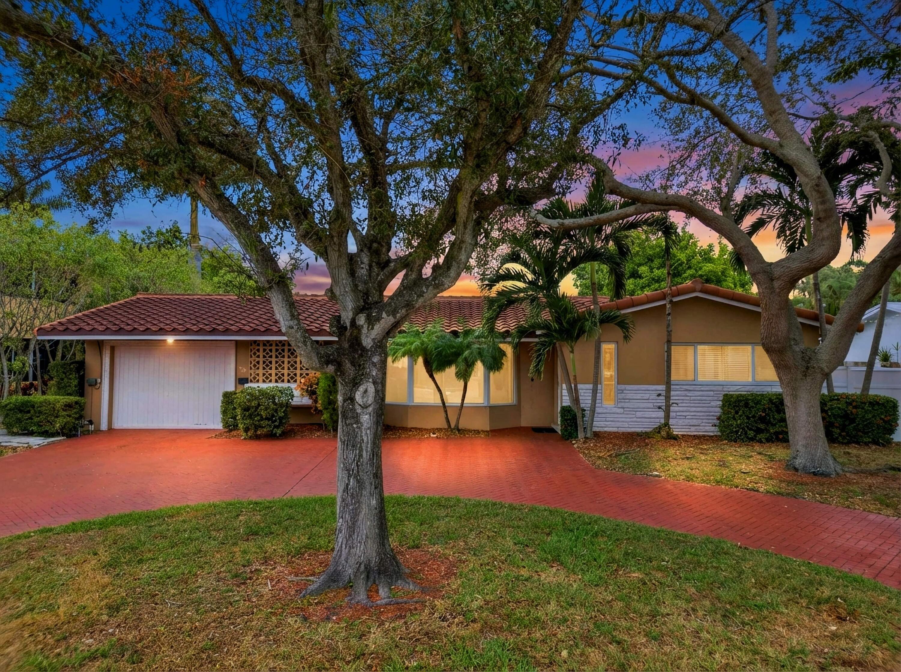 a view of a house with a tree and a yard