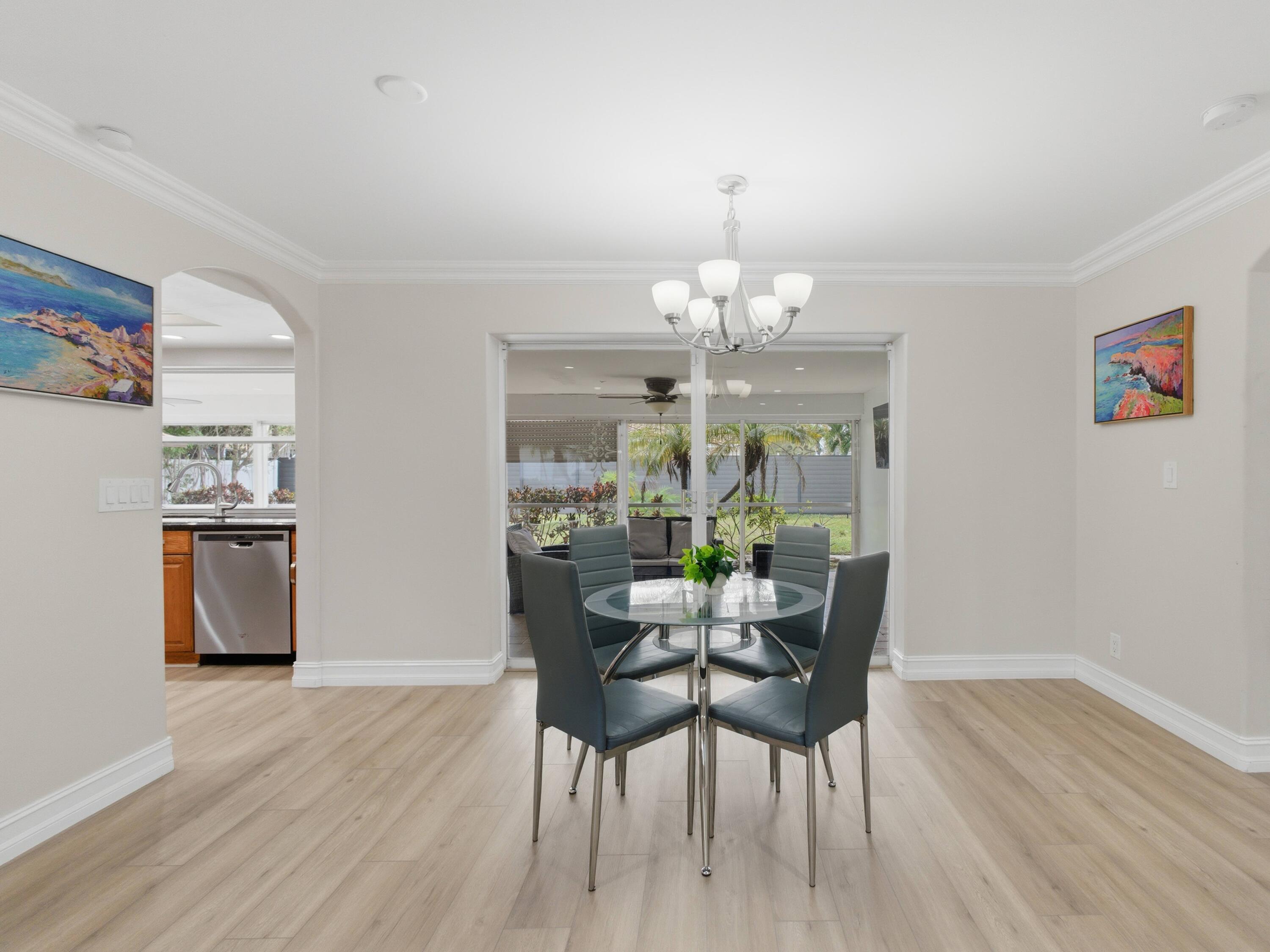 1921 Northeast 28th Court Lighthouse Point, FL 33064 - Photo 11 of 39 a view of a dining room with furniture a chandelier and wooden floor