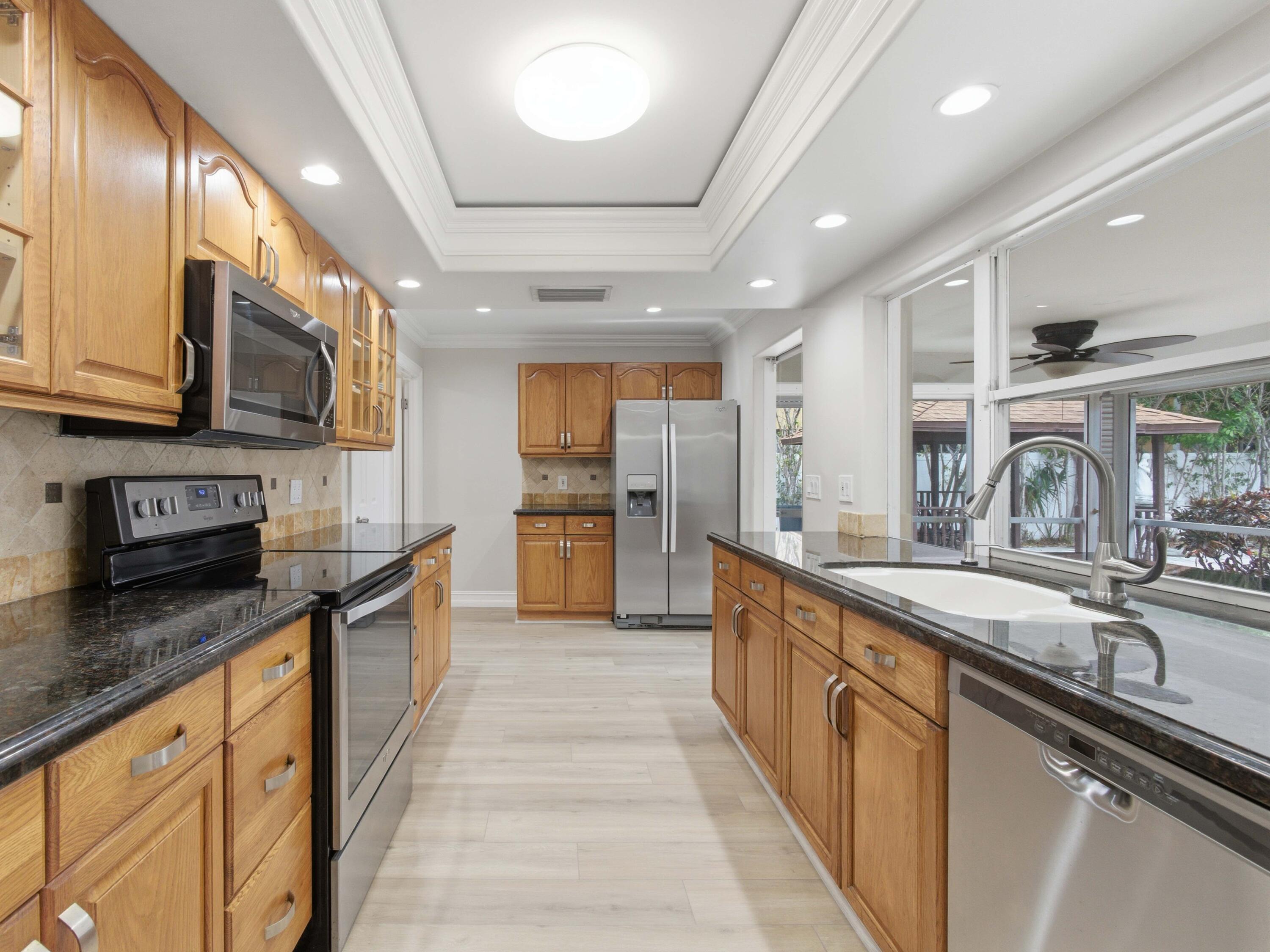 1921 Northeast 28th Court Lighthouse Point, FL 33064 - Photo 14 of 39 a large kitchen with stainless steel appliances granite countertop a sink and cabinets