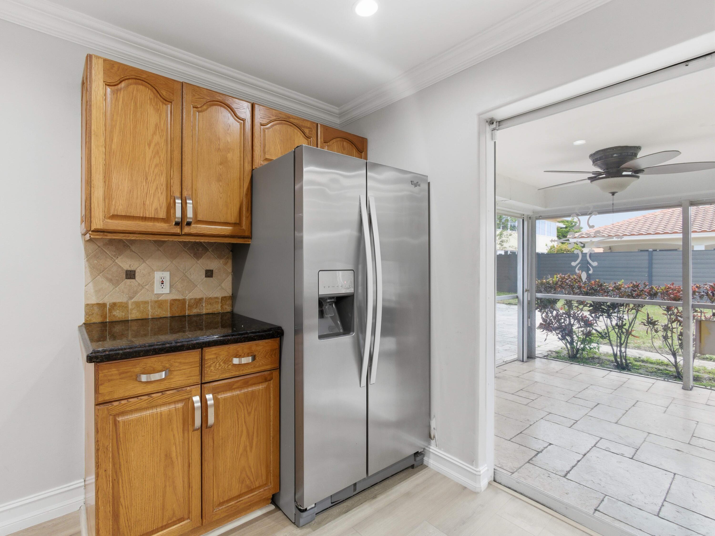 1921 Northeast 28th Court Lighthouse Point, FL 33064 - Photo 17 of 39 a kitchen with granite countertop a refrigerator and cabinets