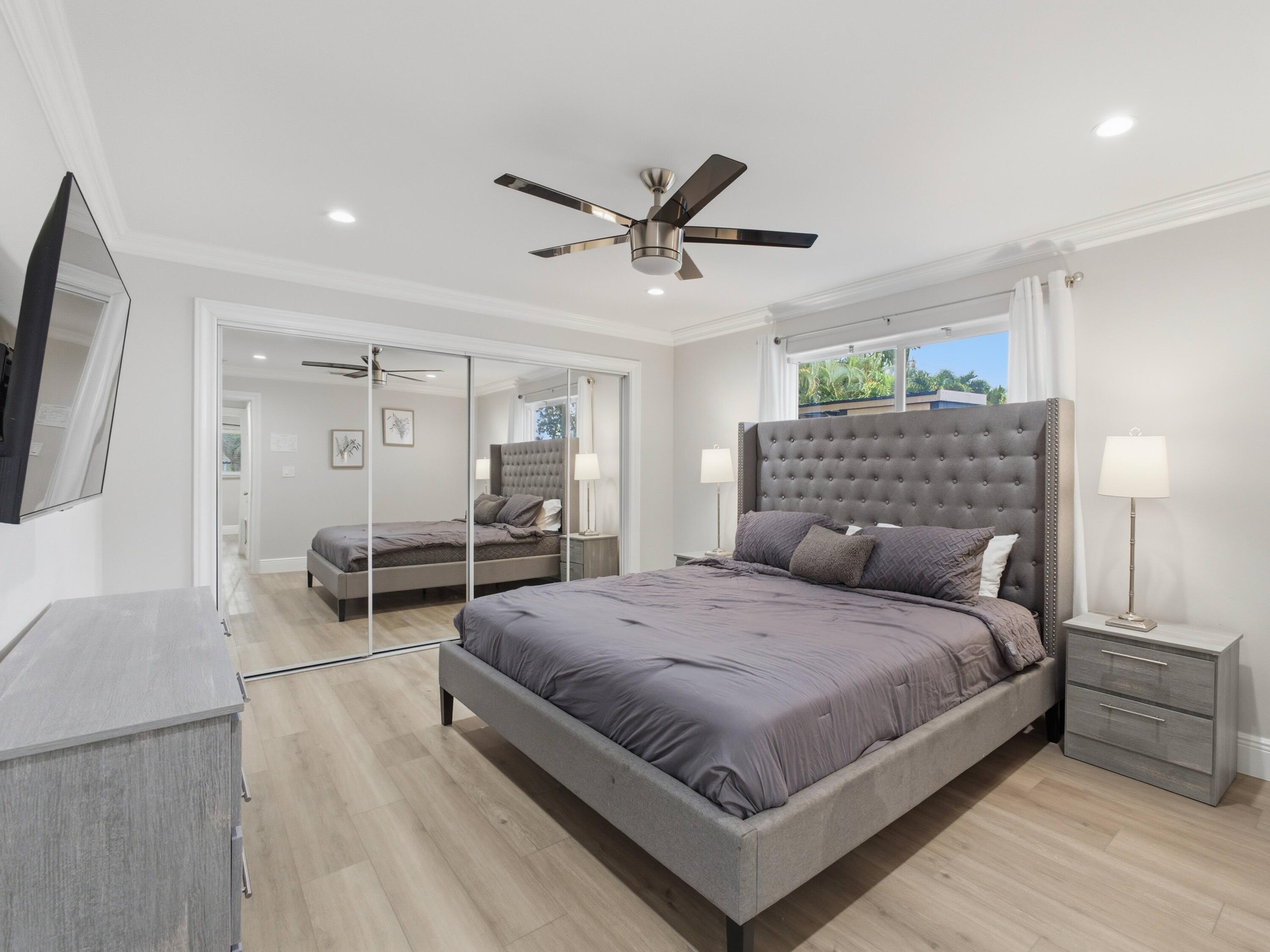 1921 Northeast 28th Court Lighthouse Point, FL 33064 - Photo 19 of 39 a bedroom with a bed and a large mirror