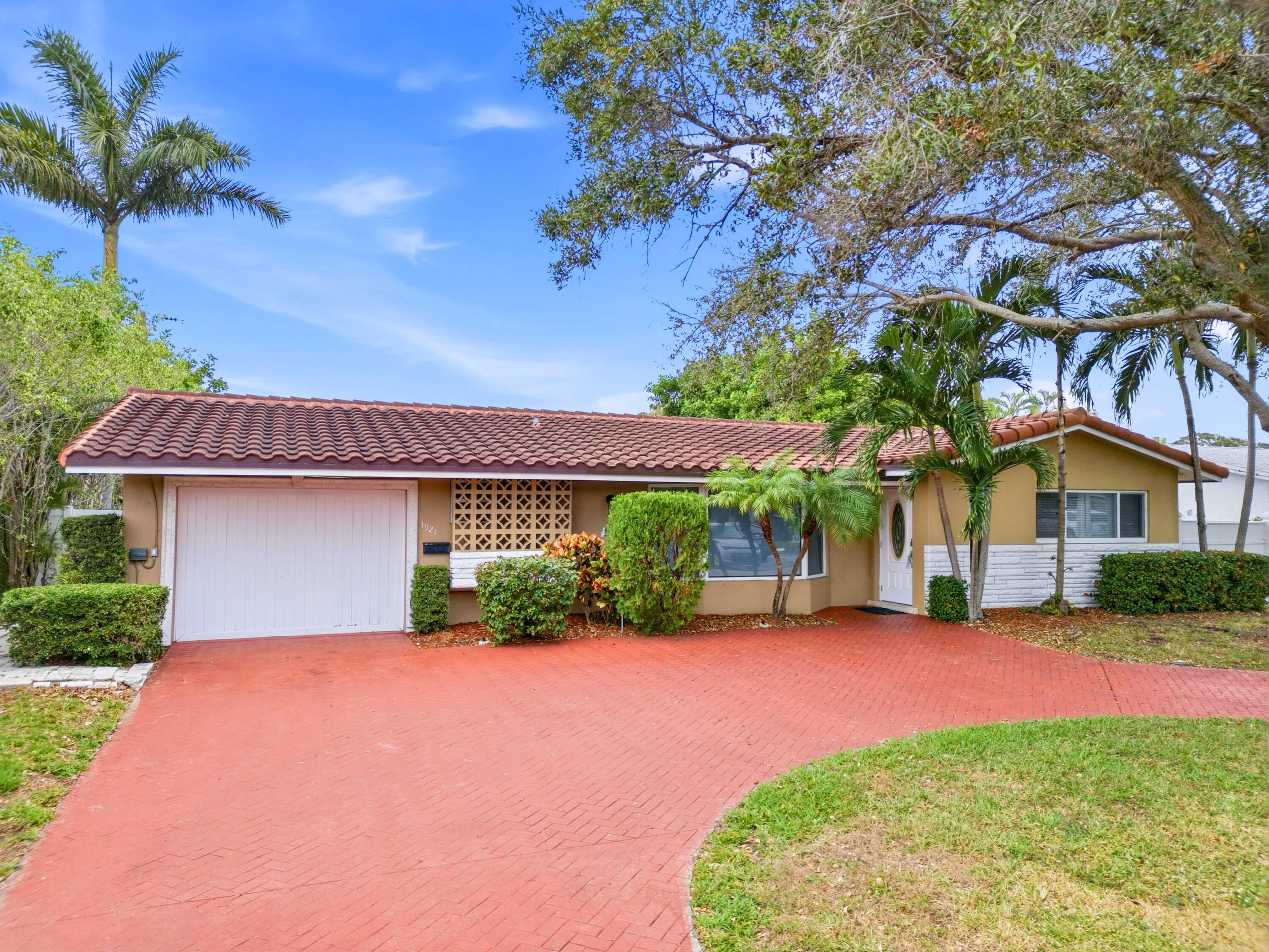 1921 Northeast 28th Court Lighthouse Point, FL 33064 - Photo 2 of 39 a front view of a house with a yard and garage