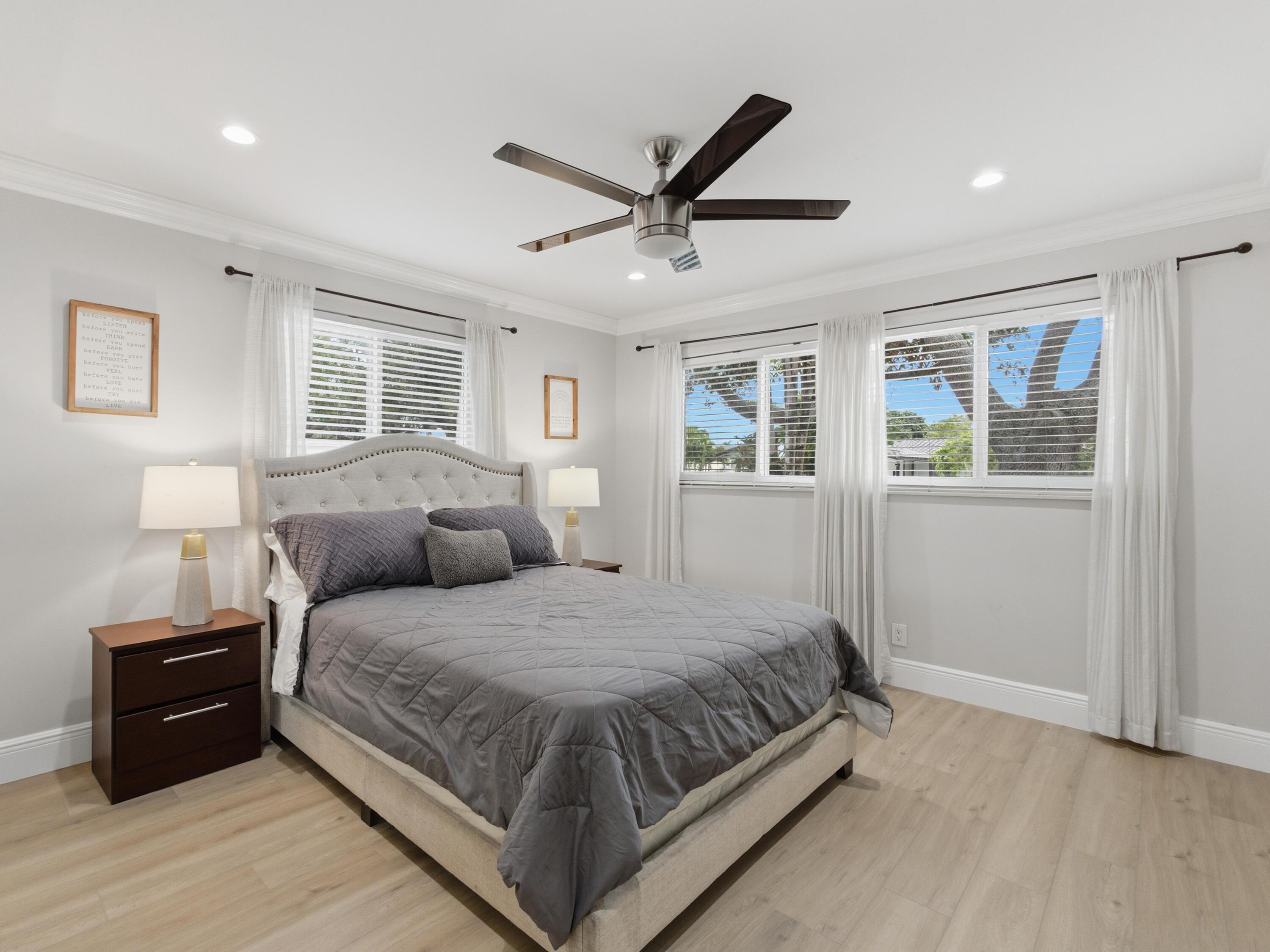 1921 Northeast 28th Court Lighthouse Point, FL 33064 - Photo 21 of 39 a bedroom with a large bed and a ceiling fan