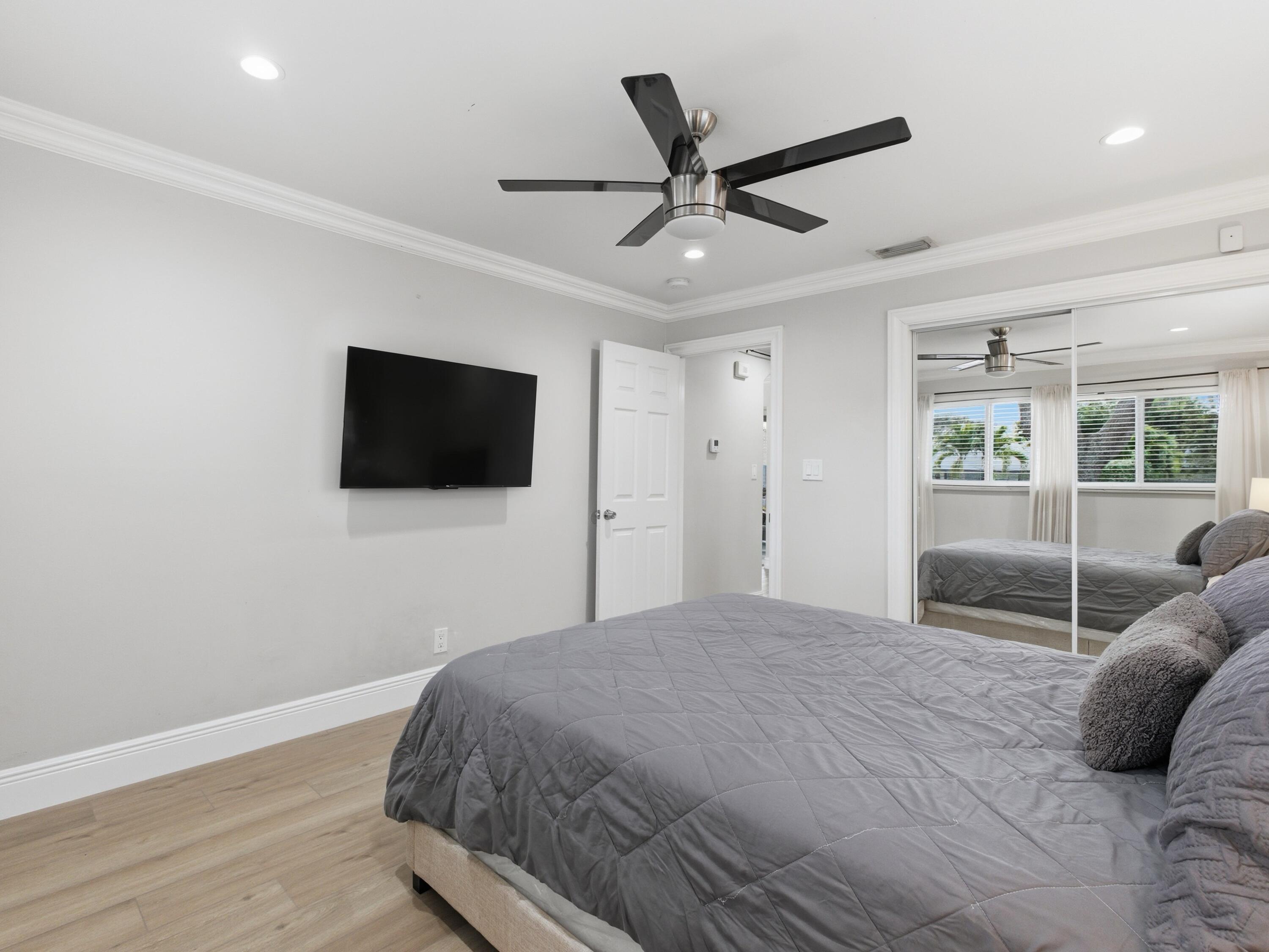 1921 Northeast 28th Court Lighthouse Point, FL 33064 - Photo 22 of 39 a bedroom with a bed tv and a window