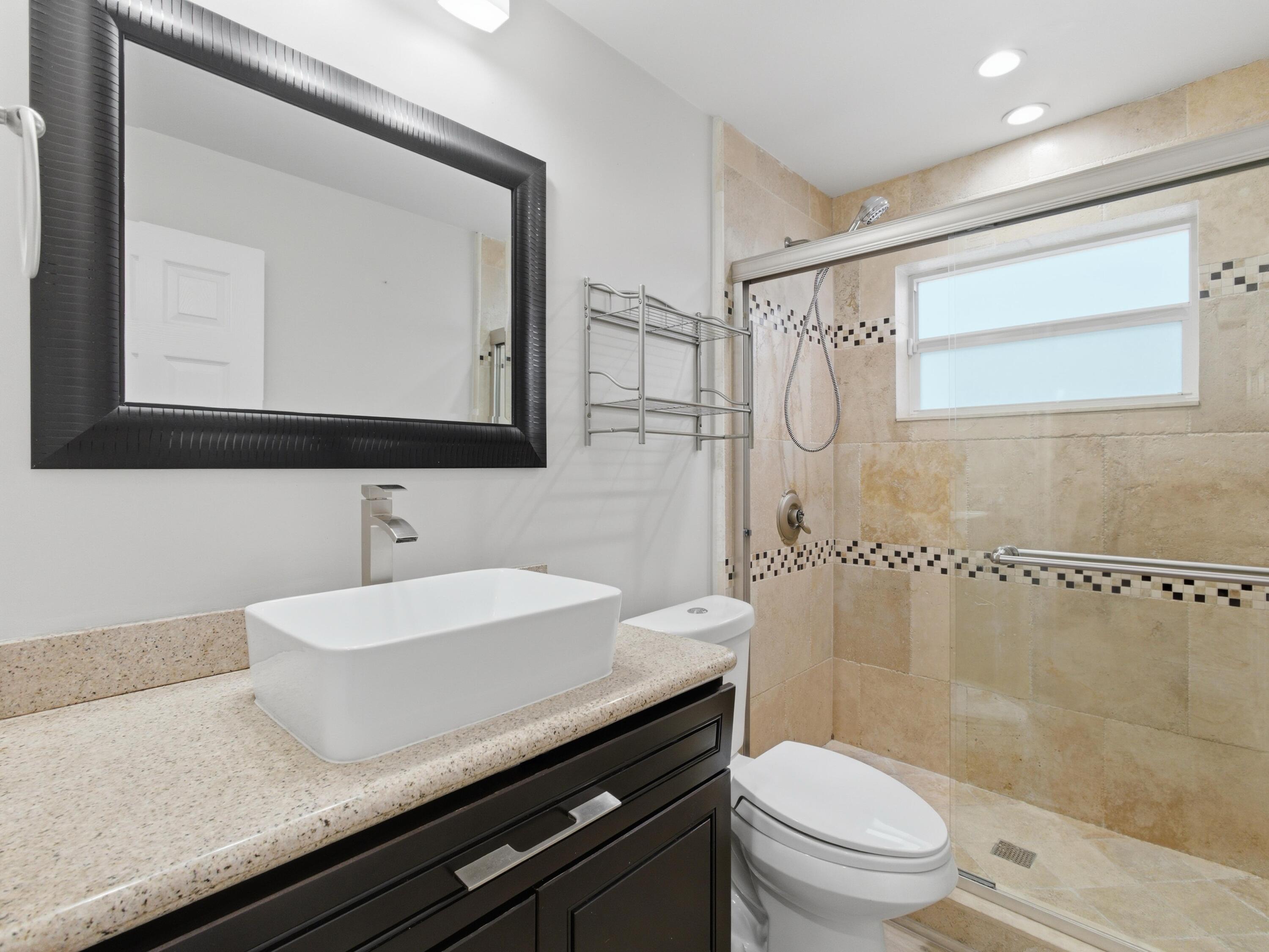 1921 Northeast 28th Court Lighthouse Point, FL 33064 - Photo 23 of 39 a bathroom with a sink a toilet and shower