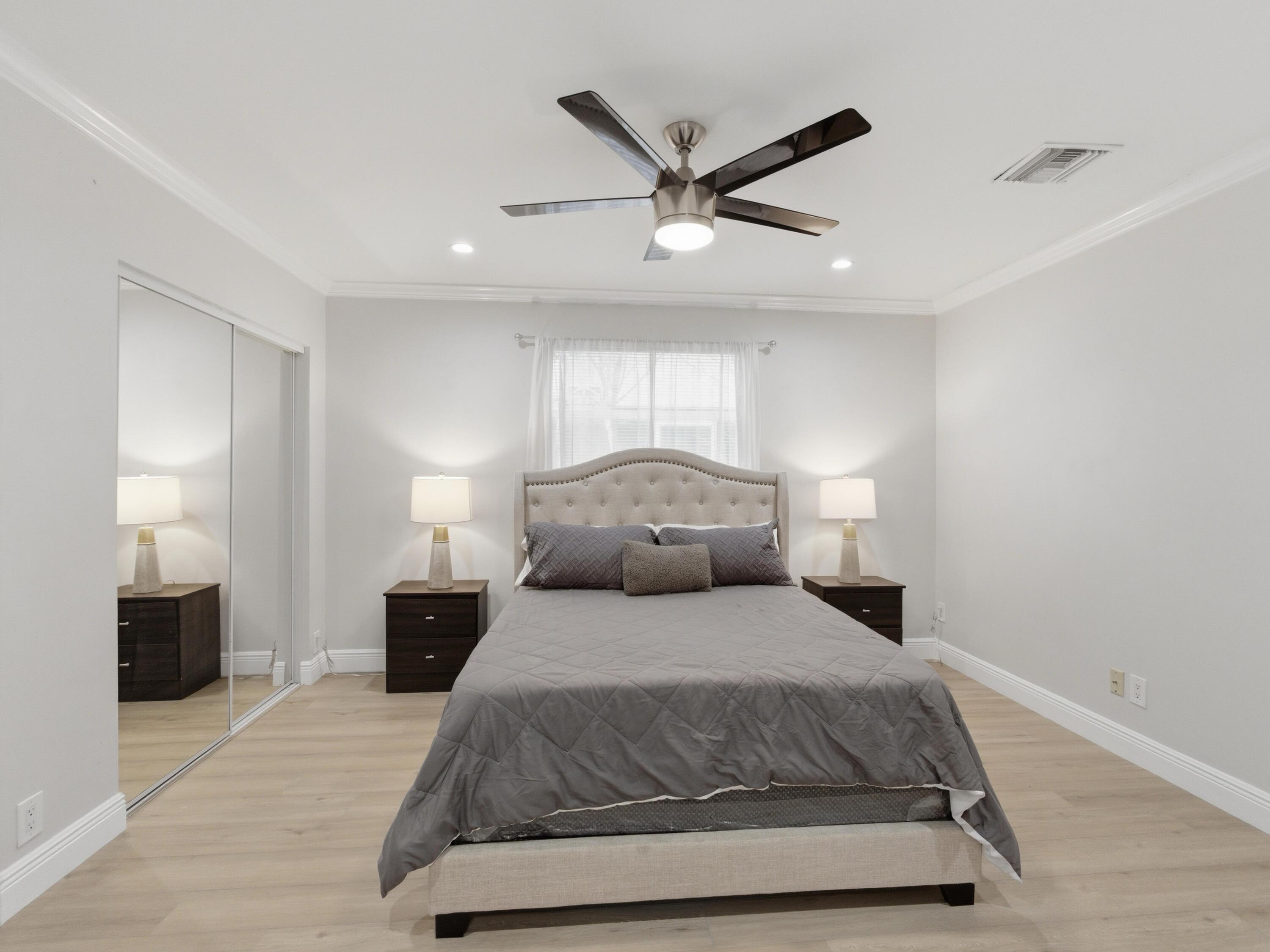 1921 Northeast 28th Court Lighthouse Point, FL 33064 - Photo 24 of 39 a bedroom with a large bed and a chandelier