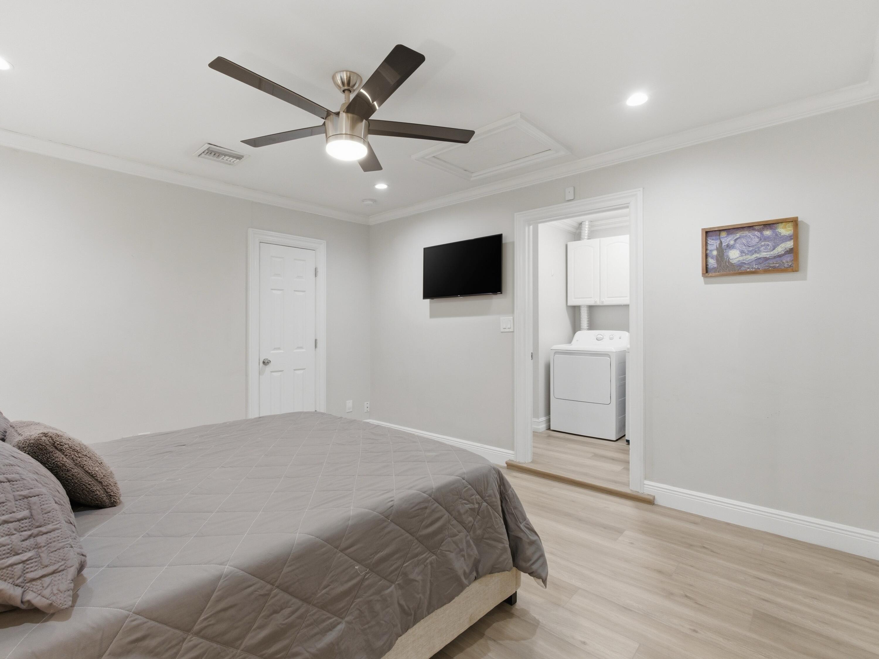 1921 Northeast 28th Court Lighthouse Point, FL 33064 - Photo 25 of 39 a bedroom with a large bed and a flat screen tv