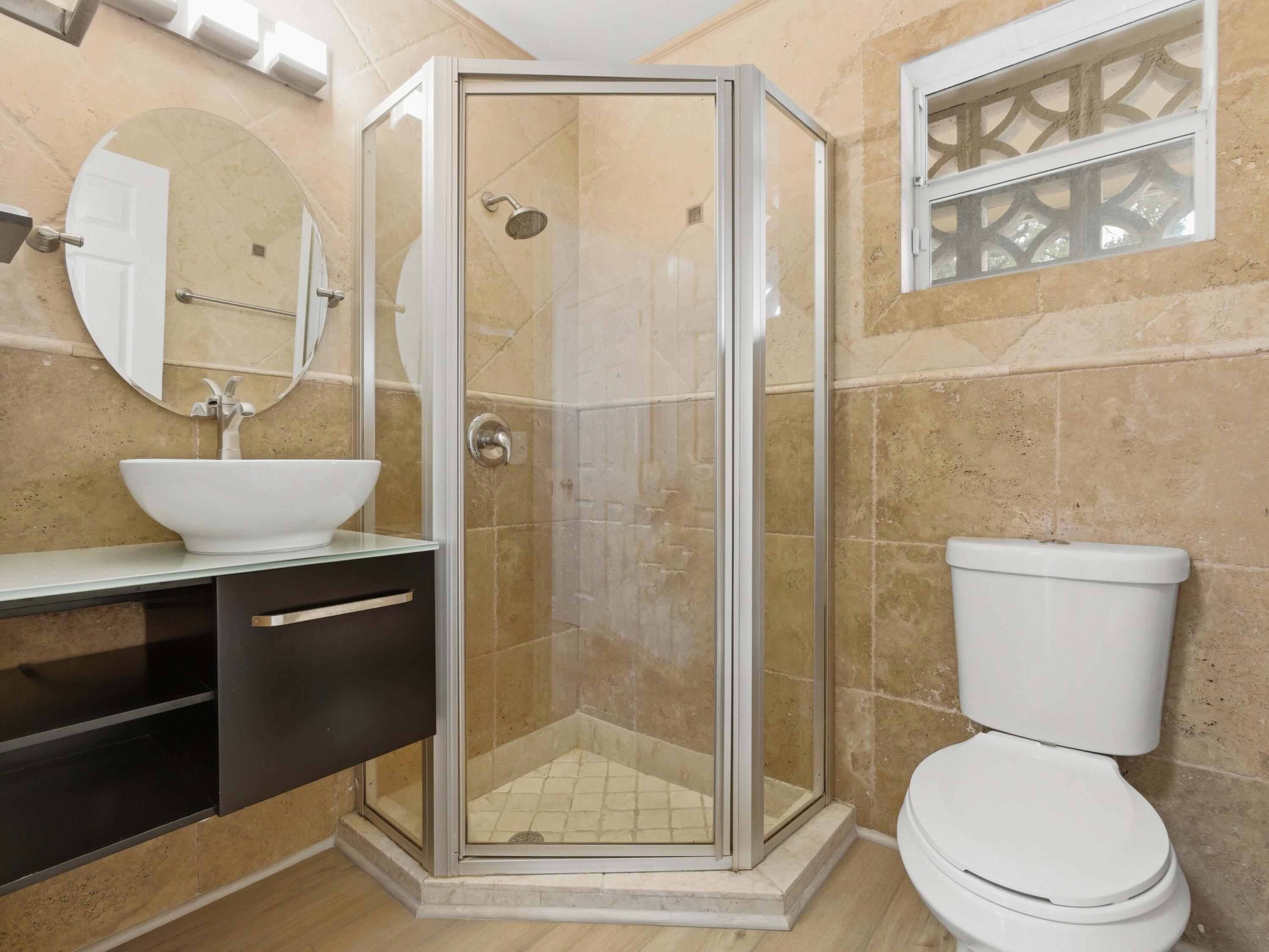 1921 Northeast 28th Court Lighthouse Point, FL 33064 - Photo 26 of 39 a bathroom with a toilet a sink and glass door
