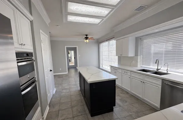 a kitchen with a sink window and cabinets