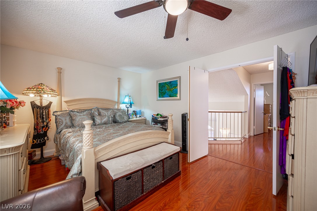 718 Rusty Spur Drive Henderson, NV 89014 - Photo 46 of 50 A tranquil primary bedroom with warm wood floors and ample natural light invites restful slumber.