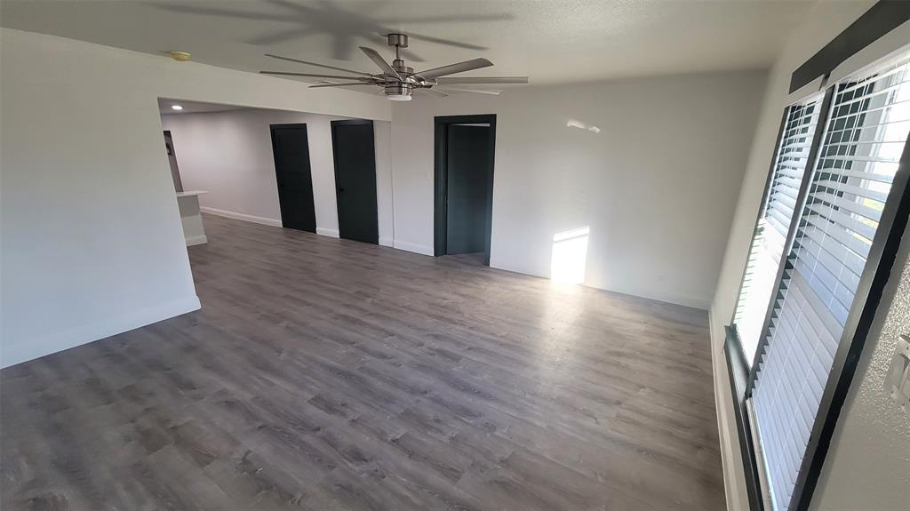 1204 Live Oak Street Commerce, TX 75428 - Photo 13 of 14 an empty room with wooden floor and staircase