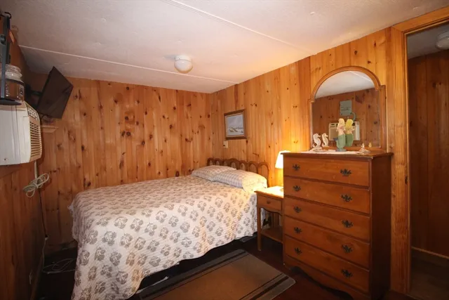 a bedroom with a bed and a mirror on the dresser