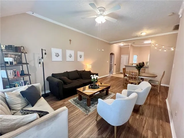 a living room with furniture and a wooden floor