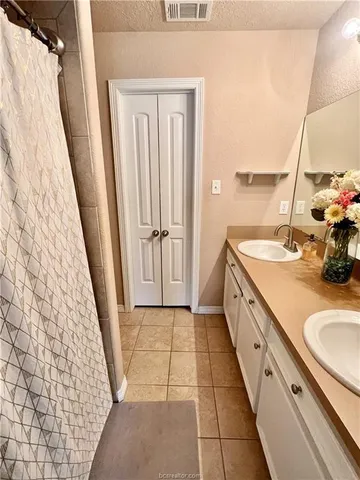 a bathroom with a sink a toilet a mirror and shower