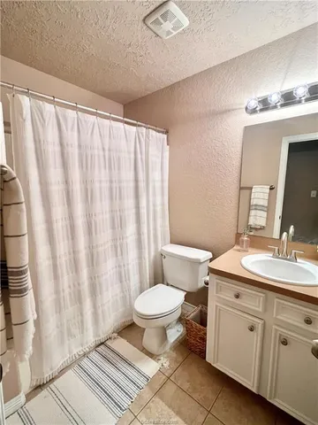 a bathroom with a double vanity sink toilet and a mirror
