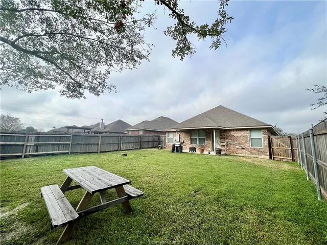 a view of a house with a yard and sitting area