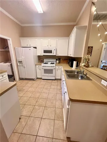 a kitchen with stainless steel appliances a sink a stove a refrigerator cabinets and a counter top space